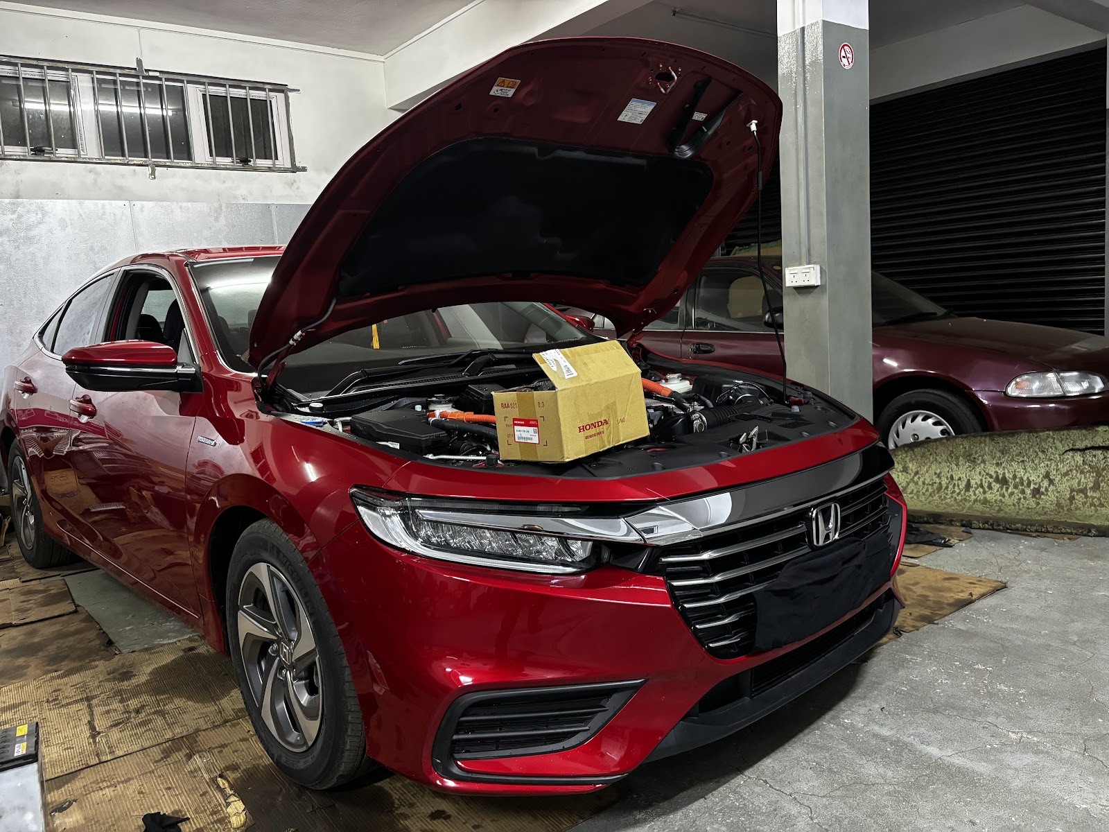 A red Honda being worked on at Pro Auto