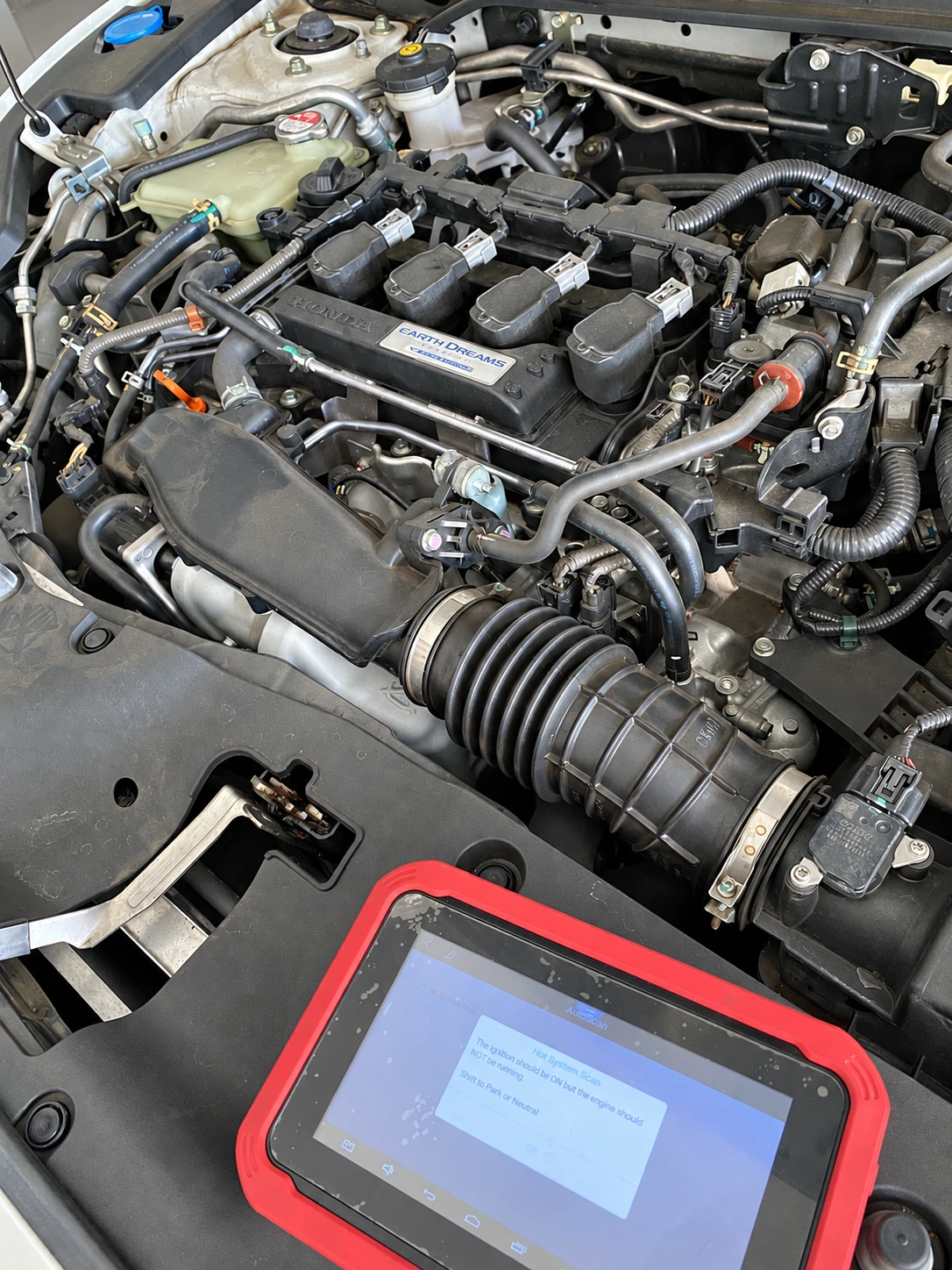 Diagnostic equipment alongside a vehicle engine at Pro Auto